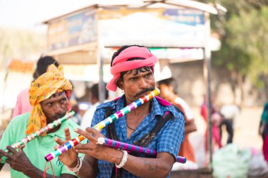 ALIRAJPUR, MADHYA PRADESH, İNDİYA, 15 Mart 2022: Hint bhil kabilesi davulda dans eden insanlar Bhagoria Festivali sırasında wiyh flüt çaldılar.