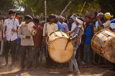  ALIRAJPUR, MADHYA PRADESH, INDIA, 15 Mart 2022: Bhagoria kabile festivalinde davul çalan kabile kadın ve erkekleri, bu festivalde evlenmeden önce erkek ve kız çocuklarını seçiyorlar