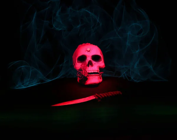 Halloween motif, composed of a skull and a dagger, in a light environment, with the technique of painting with ligh