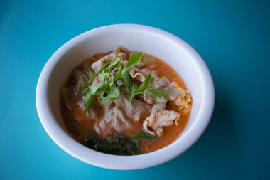 Mavi arka planda beyaz bir fincanda domuz suki.