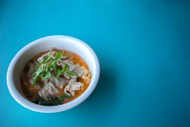 Mavi arka planda beyaz bir fincanda domuz suki.