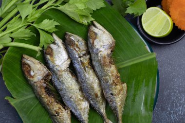 Bol yağda kızartılmış uskumru ve sebze.