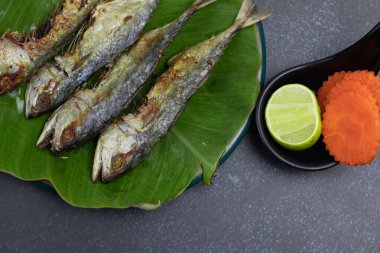 Bol yağda kızartılmış uskumru ve sebze.