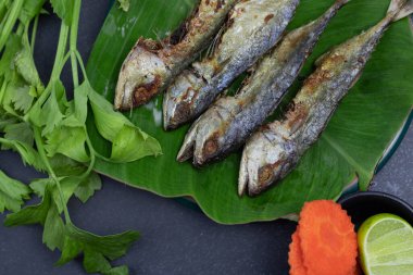 Bol yağda kızartılmış uskumru ve sebze.