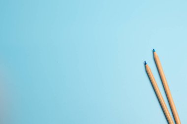 Mavi arka planda iki kalem.