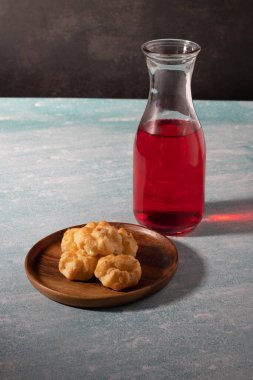 Mavi arka planda ahşap bir tabakta pasta.
