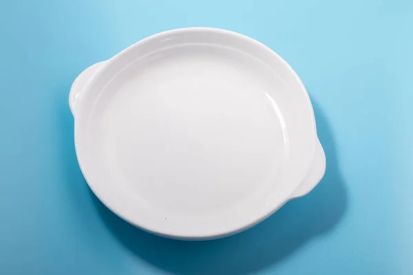 Ein Weißer Teller Auf Blauem Hintergrund — Stockfoto