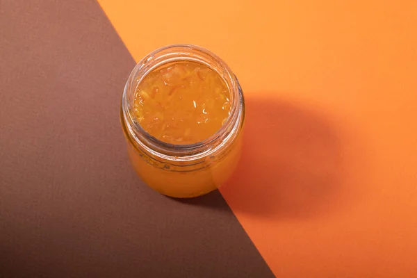 Dżem Pomarańczowy Szklanym Słoiku Brązowym Pomarańczowym Tle — Zdjęcie stockowe