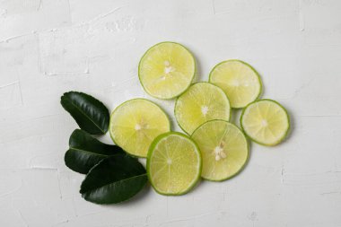 Beyaz arka planda yaprakları olan dilimlenmiş limon