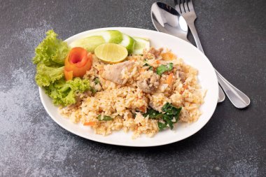 Siyah arka planda beyaz tabakta kızarmış domuz pirinci.