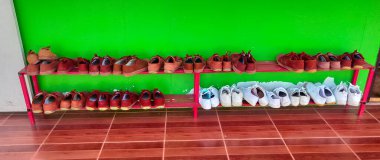 Kahverengi ve beyaz öğrenci ayakkabıları yerde yatıyordu..