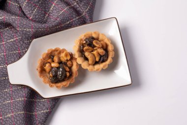 Beyaz arka planda kurabiye, fındık ve kuru üzüm