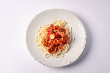 Beyaz seramik tabakta domates soslu spagetti.