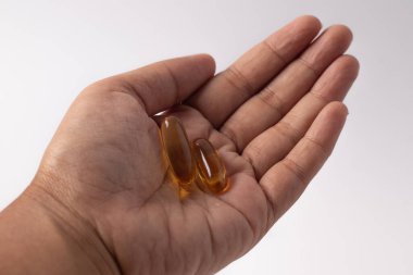 Elinde morina yağıyla sarımsak, beyaz arka plan.