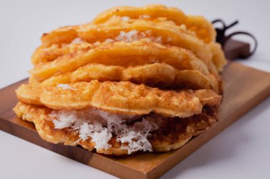 Tahta kesme tahtasında hindistan cevizli waffle, beyaz arkaplan