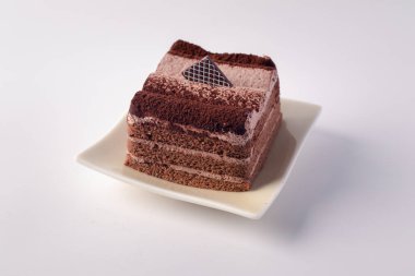 Çikolatalı pasta beyaz arka planda bir tabakta katmanlanmış..