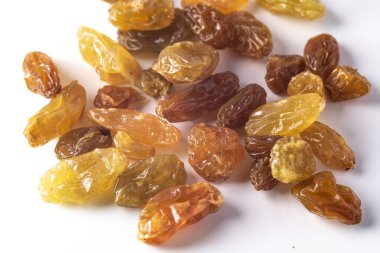 Kapatın. Kuru üzümler beyaz arkaplanda birikiyor.