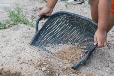 İnsanlar inşaat için kum toplamak için sepet kullanıyorlar..