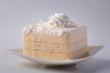 Beyaz arka planda beyaz kremalı hindistan cevizli kek, pürüzsüz ve ince desenli