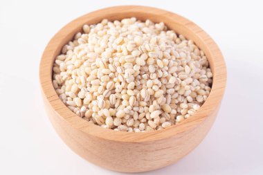 Beyaz arka planda tahta bir fincanda arpa pilavı.