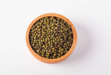 Beyaz arka planda, tahta bir fincanda yeşil fasulyeler.