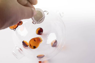 Eller domuz kumbarasına bozuk para koyuyor. Para tasarruf kavramı