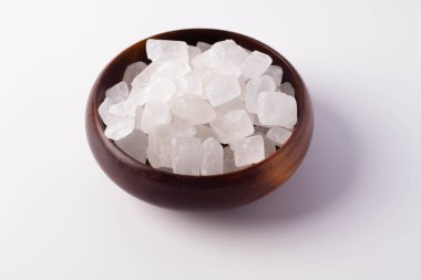 Beyaz arka planda tahta bir fincanda beyaz kaya şekeri