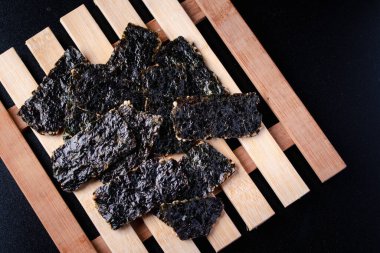 Kıtır yosun, siyah sırtlı, ahşap bir zeminde yatıyor..