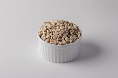 Beyaz arka planda beyaz bir seramik bardaktaki iş gözyaşları.