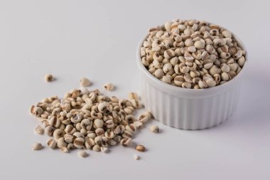 Beyaz arka planda beyaz bir seramik bardaktaki iş gözyaşları.