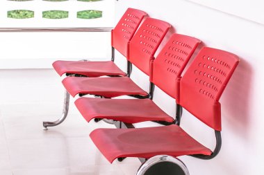 Kırmızı sandalyeler beyaz odanın önünde dizildi..