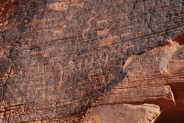 Ancient symbols on red sandstone in the Valley of Fire, Nevada, USA; people and animals petroglyphs
