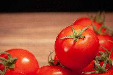 Sağ tarafı domatesli büyük, olgun, kırmızı bir domates.