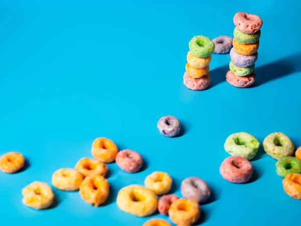 many colorful sugary cereal rings on a blue background