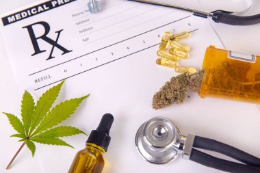 Assorted cannabis products, pills and cbd oil over medical prescription sheet - medical marijuana concept