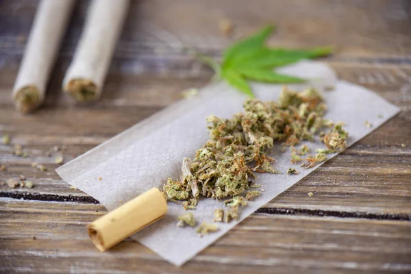大麻联接与滚动纸在木头背景 医疗大麻概念 — 图库照片