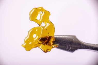 Dab aracı esrar ile makro detayını konsantre aka beyaz arka plan üzerinde tıbbi esrar ayıklama kavramı izole paramparça