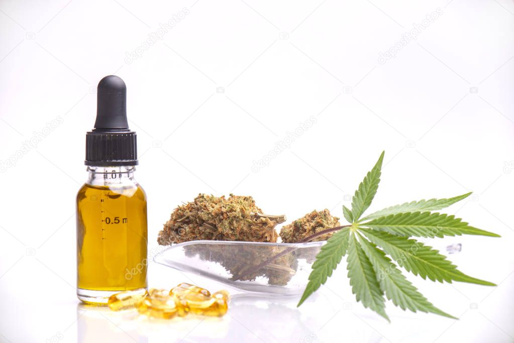 Assorted medical cannabis products with nug and leaf, capsules and CBD oil isolated over white background