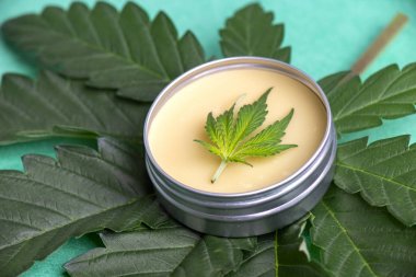 Yeşil arka plan üzerinde kenevir ve Cbd yağı ile Esrar merhem