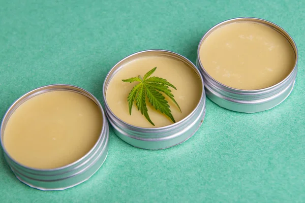 Cannabis salve com cânhamo e óleo de CBD sobre fundo verde — Fotografia de Stock