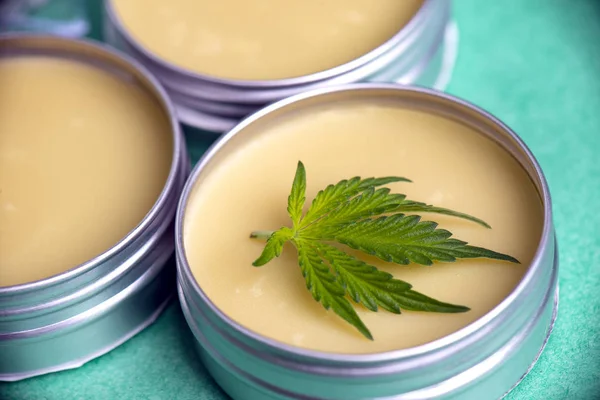 Cannabis salve com cânhamo e óleo de CBD sobre fundo verde — Fotografia de Stock