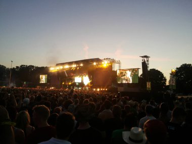Açık havada bir sürü insanın olduğu bir akşam konseri.