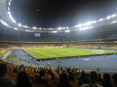Akşamleyin büyük bir stadyumda yapılan futbol müsabakasında trislerden parlak bir röfle kaldırıldı.