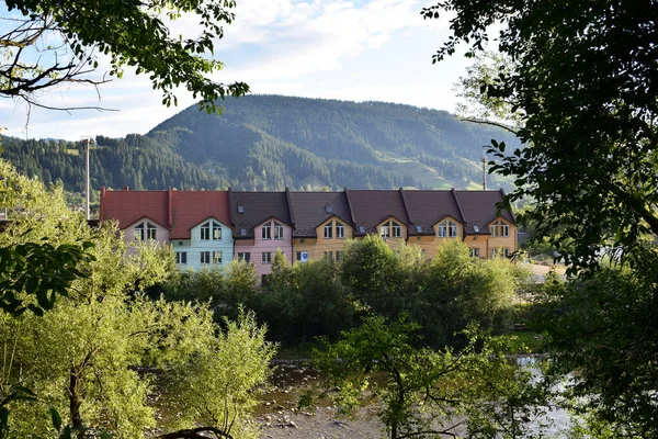 Long colorful house with a curly roof on a background of mountains — Stock Photo, Image