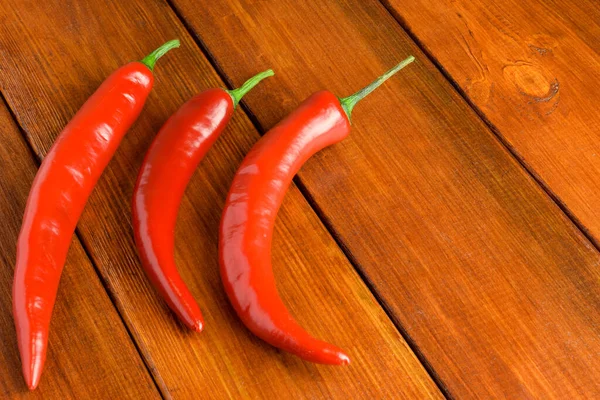 Three Pods Red Chili Peppers Lie Left Wooden Photophone — Stock Photo, Image