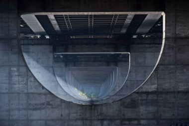 Fotoğraf, destekleri arasında geniş beton bir köprü altında çekildi ve bu köprü perspektif kazandı. Güneş ışınları destekler arasında yol alır.