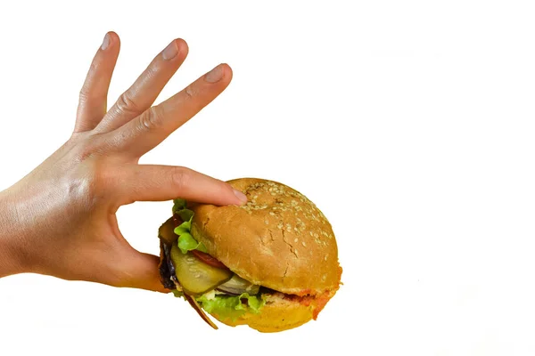 Hand holds a sandwich with meat, cheese, tomatoes, onions, cucumbers and salad on a white background — Stock Photo, Image