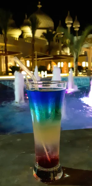 Sklenice s pestrobarevným koktejlem stojí na stole v hotelu — Stock fotografie