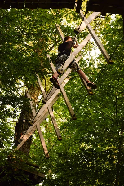 Jongeman Loopt Een Hindernisbaan Van Boom Naar Boom Een Touwenpark — Stockfoto