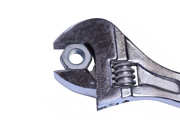 A nut is clamped in an adjustable wrench close-up on a white background — Stock Photo, Image